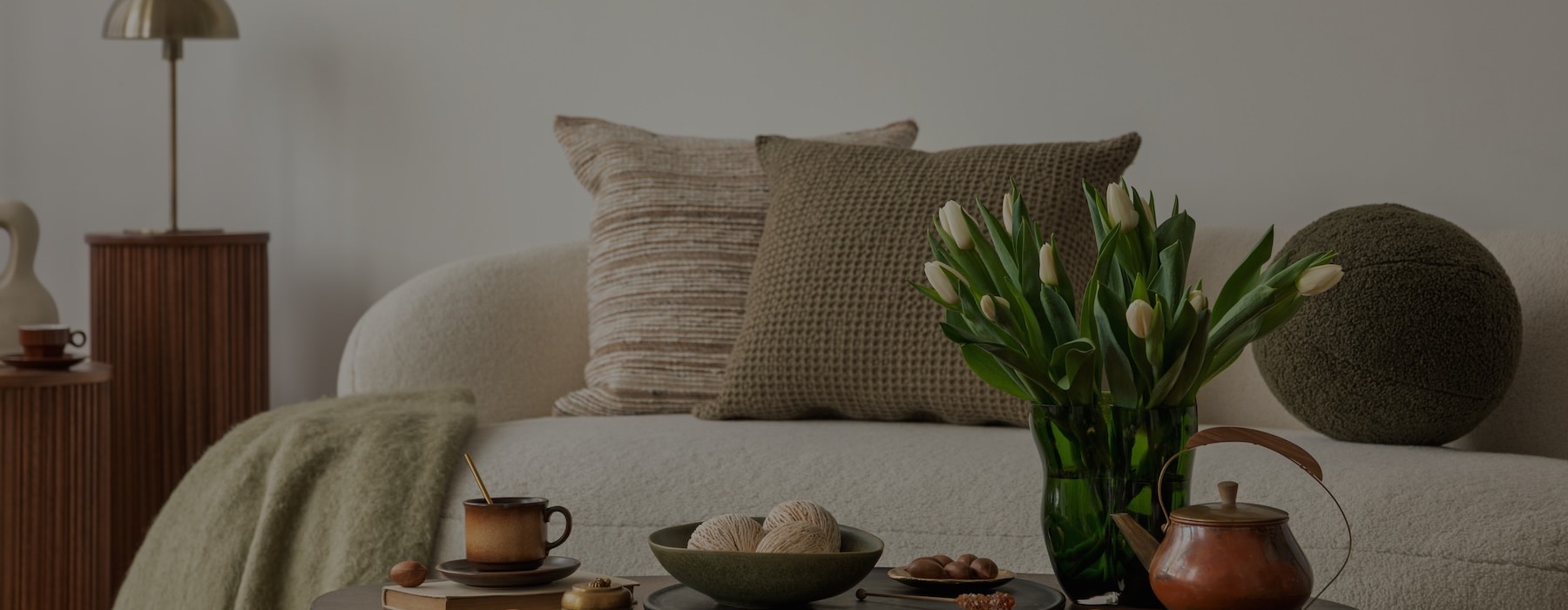 a couch with a table and a vase with flowers on it