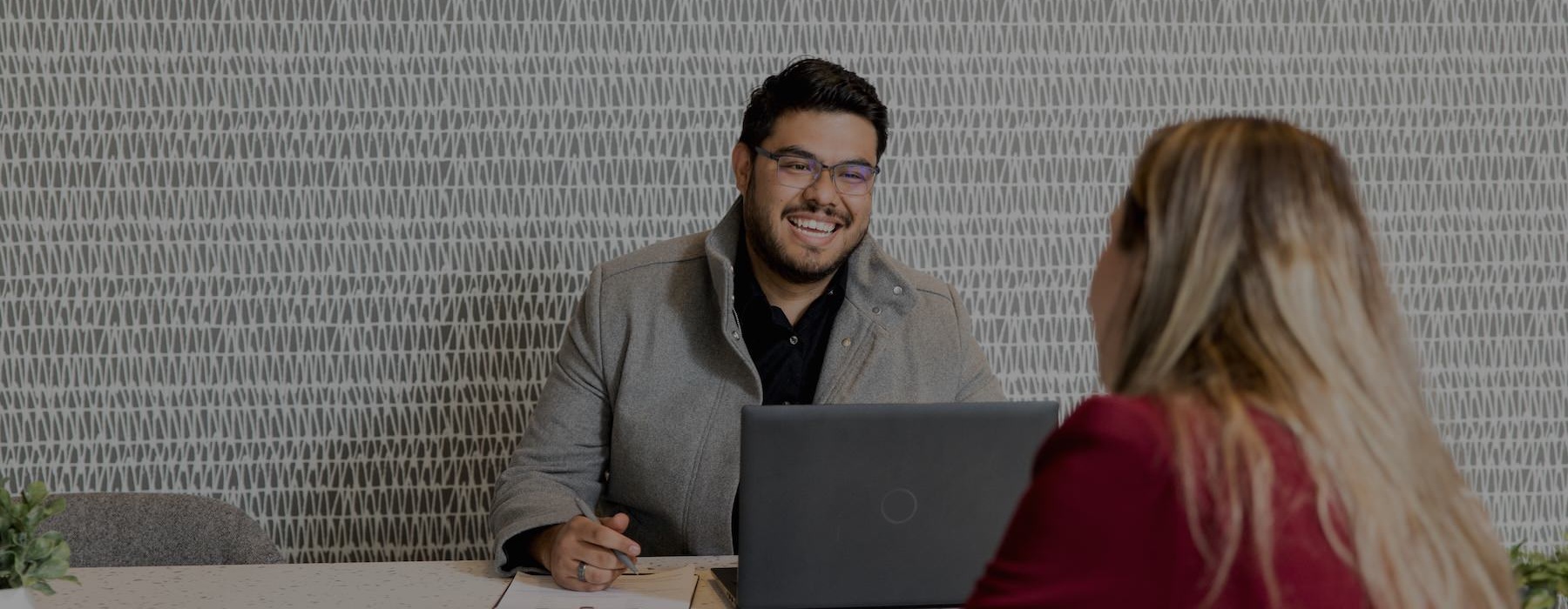 a man and a woman looking at a laptop