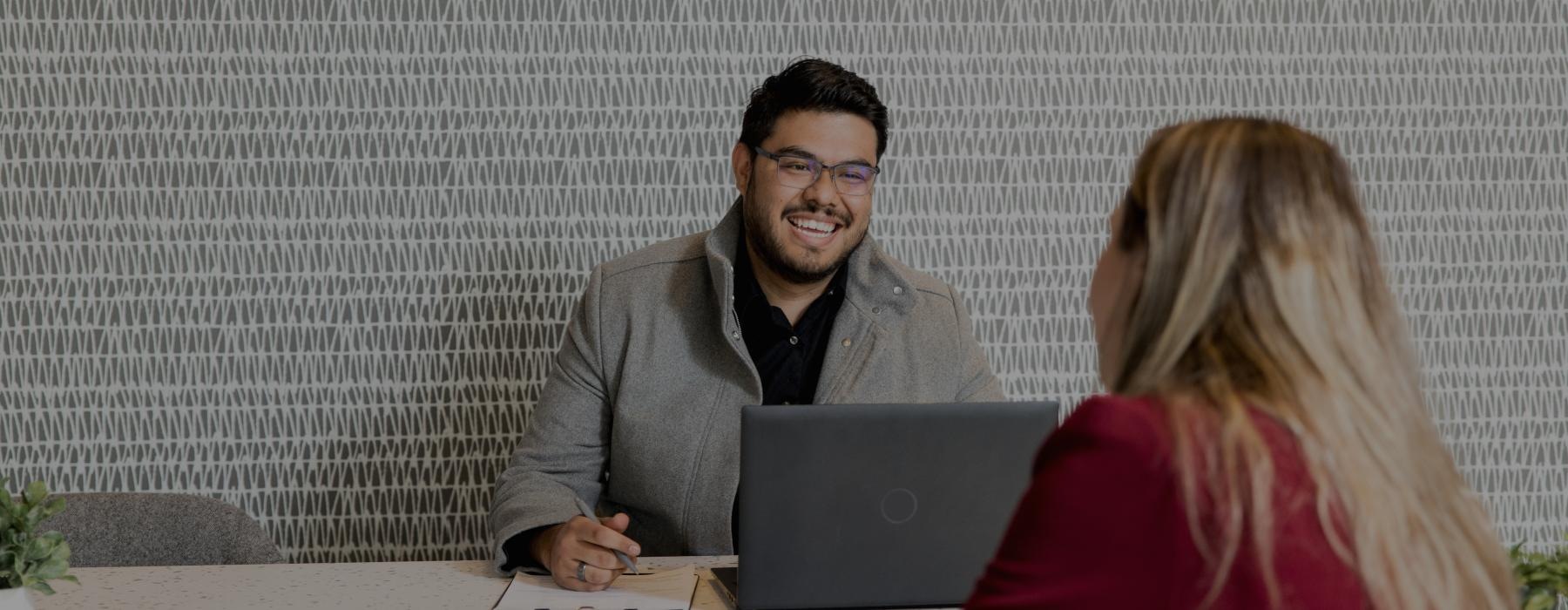 a man and a woman looking at a laptop